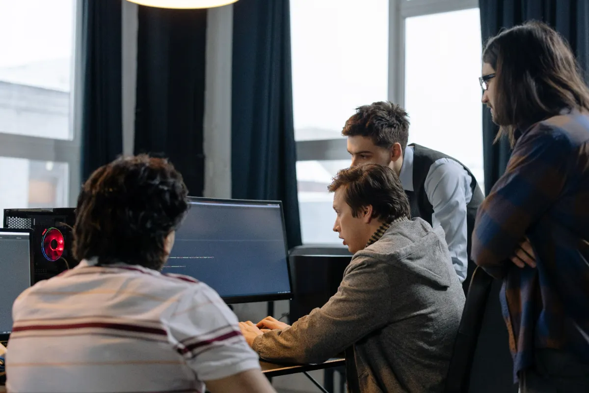 A team reviewing security monitoring on desktop screens in an office.